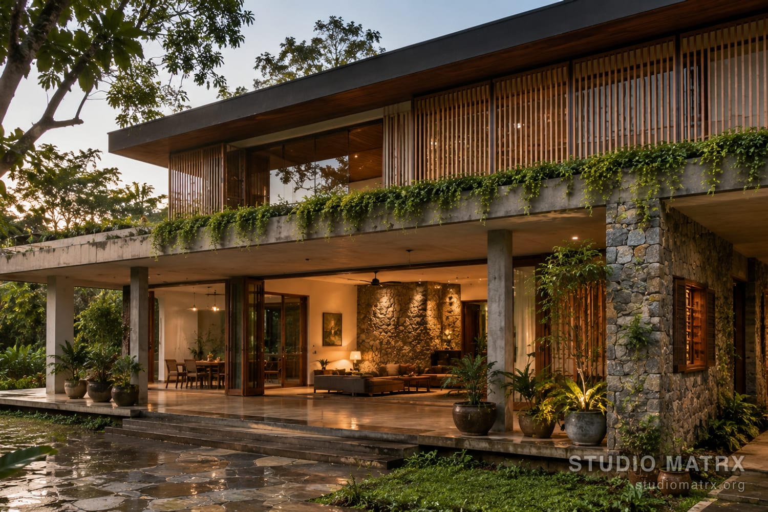 A Contemporary Tropical Indian home at dusk — open ground floor, deep overhangs, stone and timber, planting and a reflecting pool